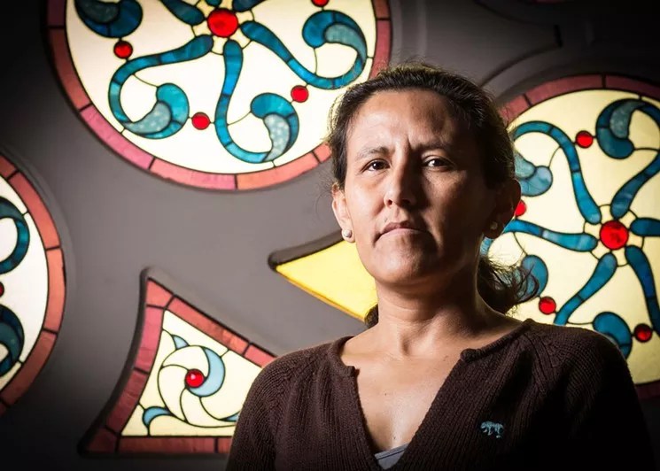 woman in front of stained glass.