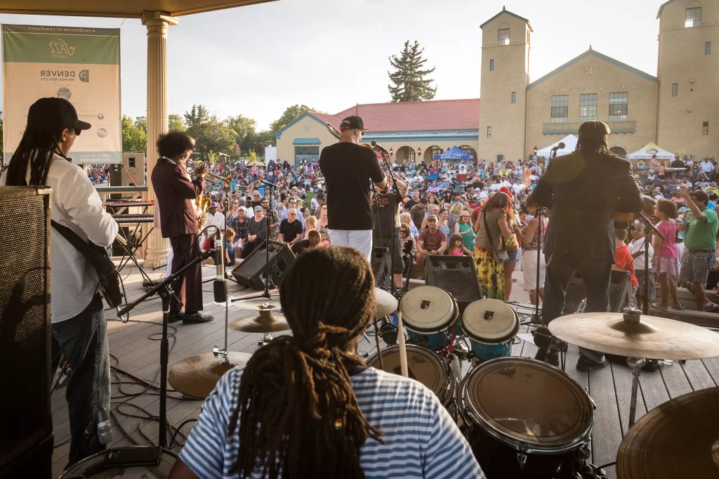 A drummer and other musicians performing on stage to an audience