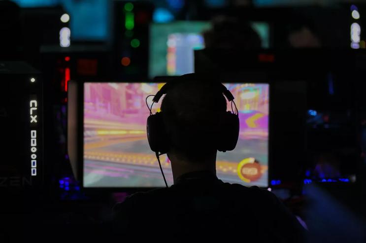 Man in headphones plays video games in the dark