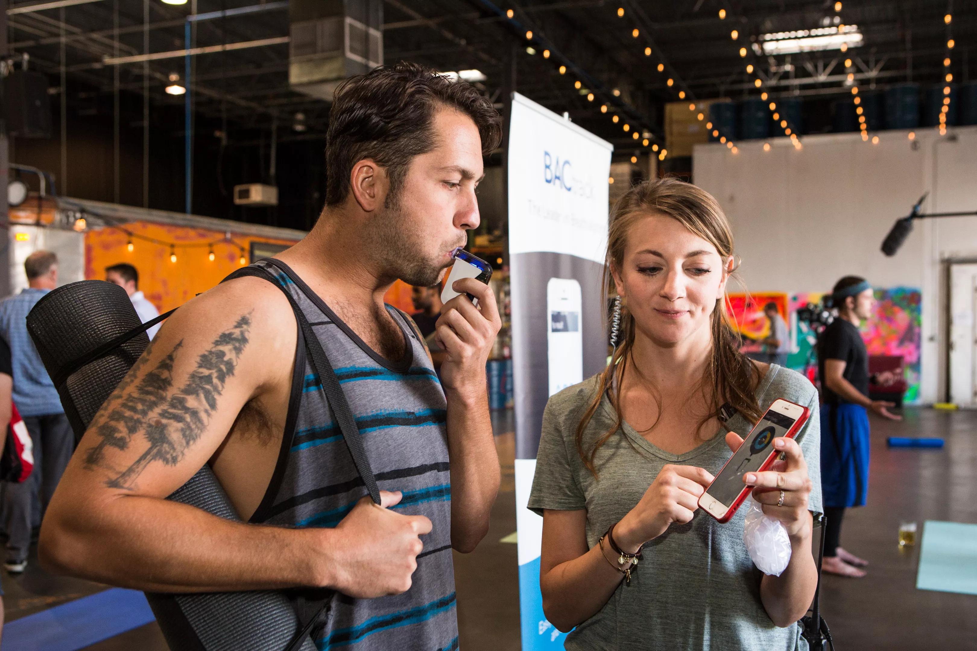 A man tests out a breathalyzer at a CDOT event