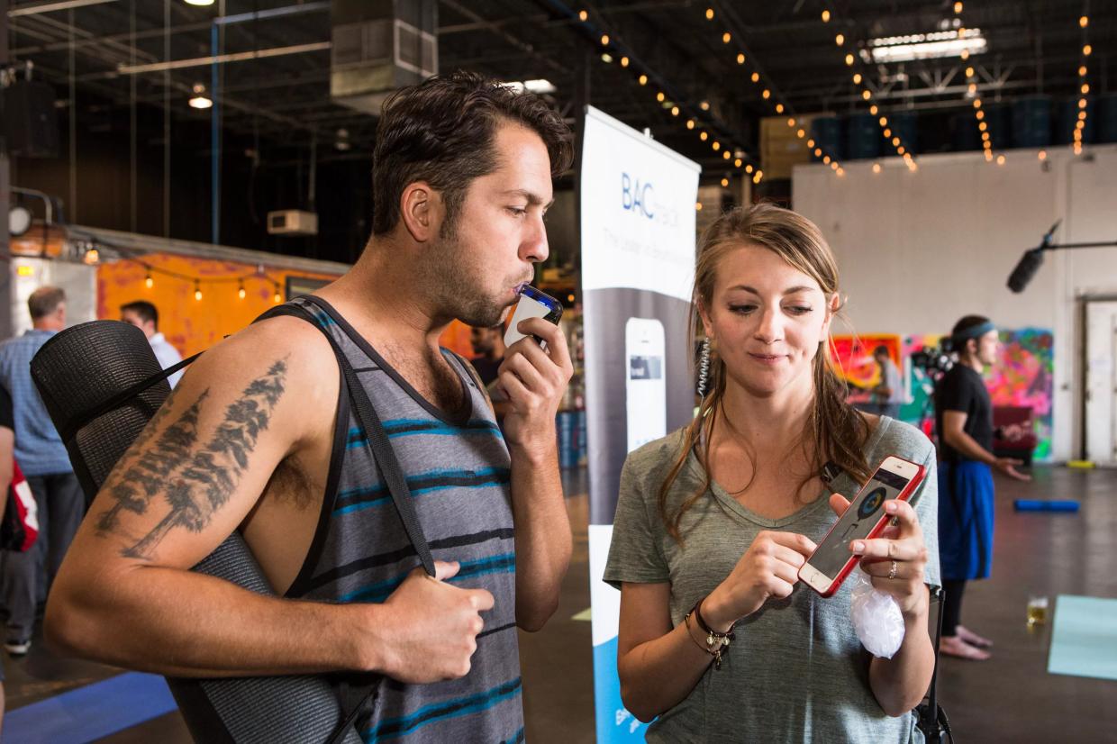A man tests out a breathalyzer at a CDOT event
