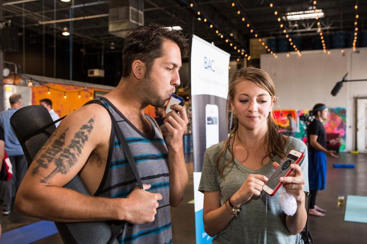 A man tests out a breathalyzer at a CDOT event