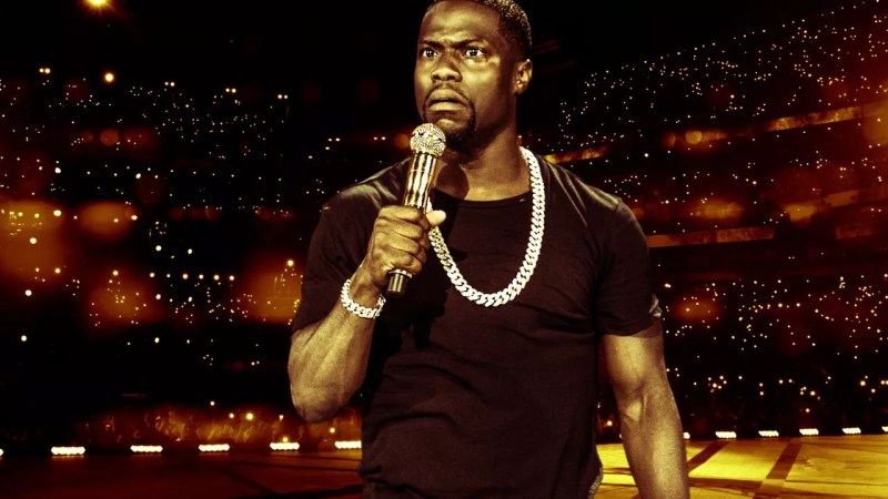 man wearing a diamond chain necklace holding a microphone