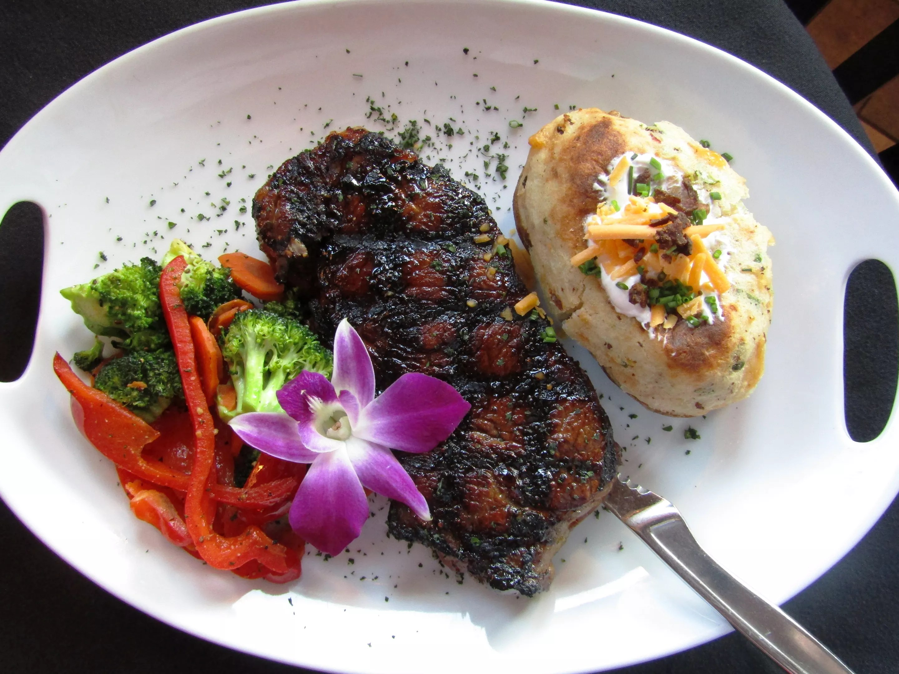 a steak on a plate with a baked potato