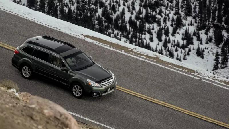 car drives down winter road