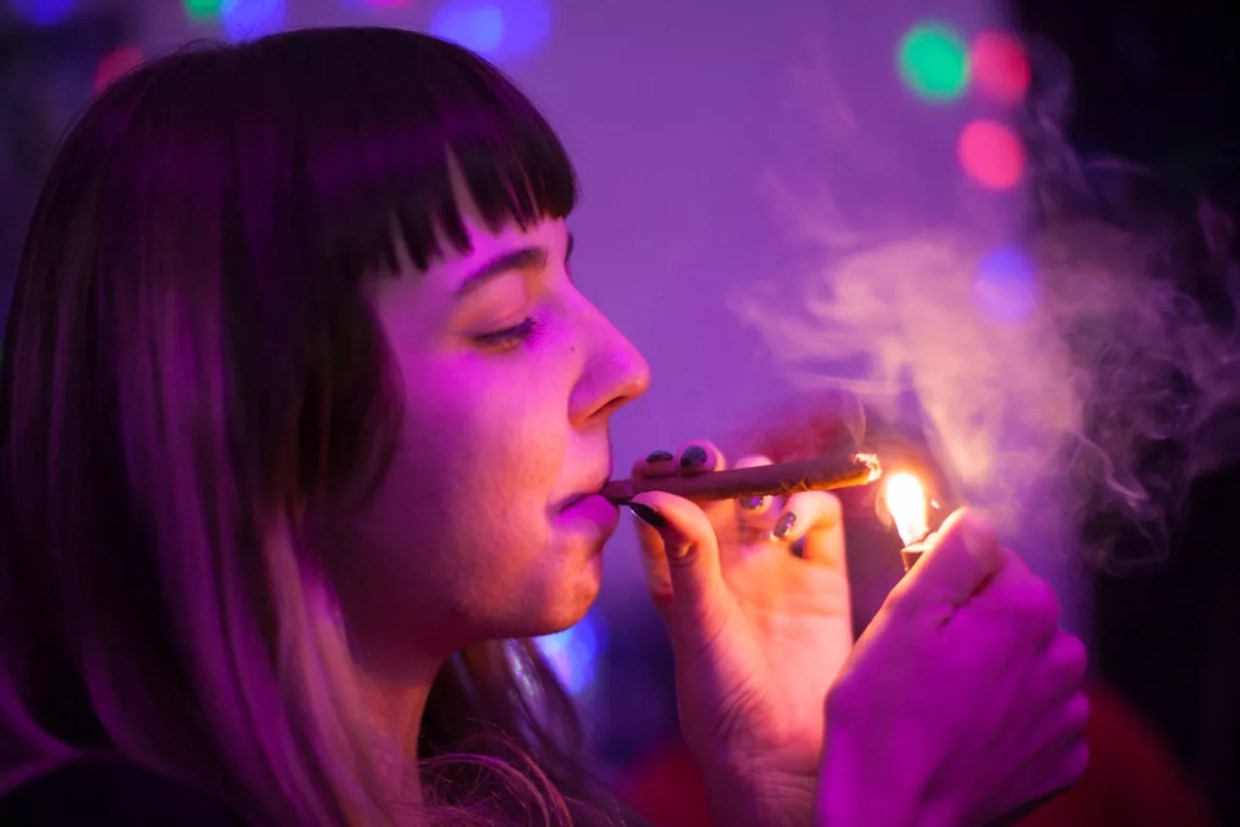 woman lights blunt inside
