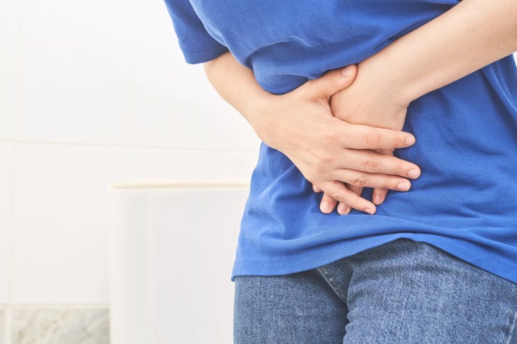 man holds stomach in pain