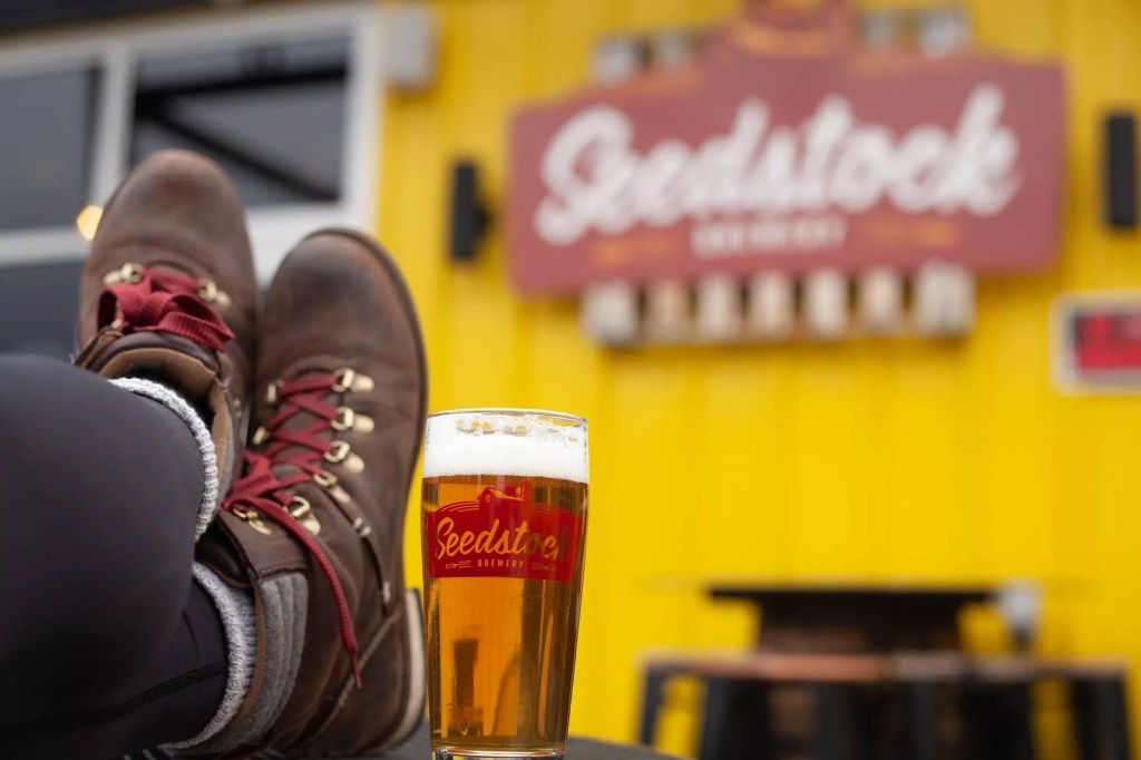 feet on a table nest to a beer