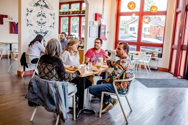 group of people sitting at a table inside a bright room