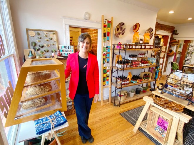 a woman in a red blazer standing in a shop