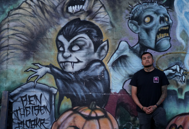 man standing in front of graffiti