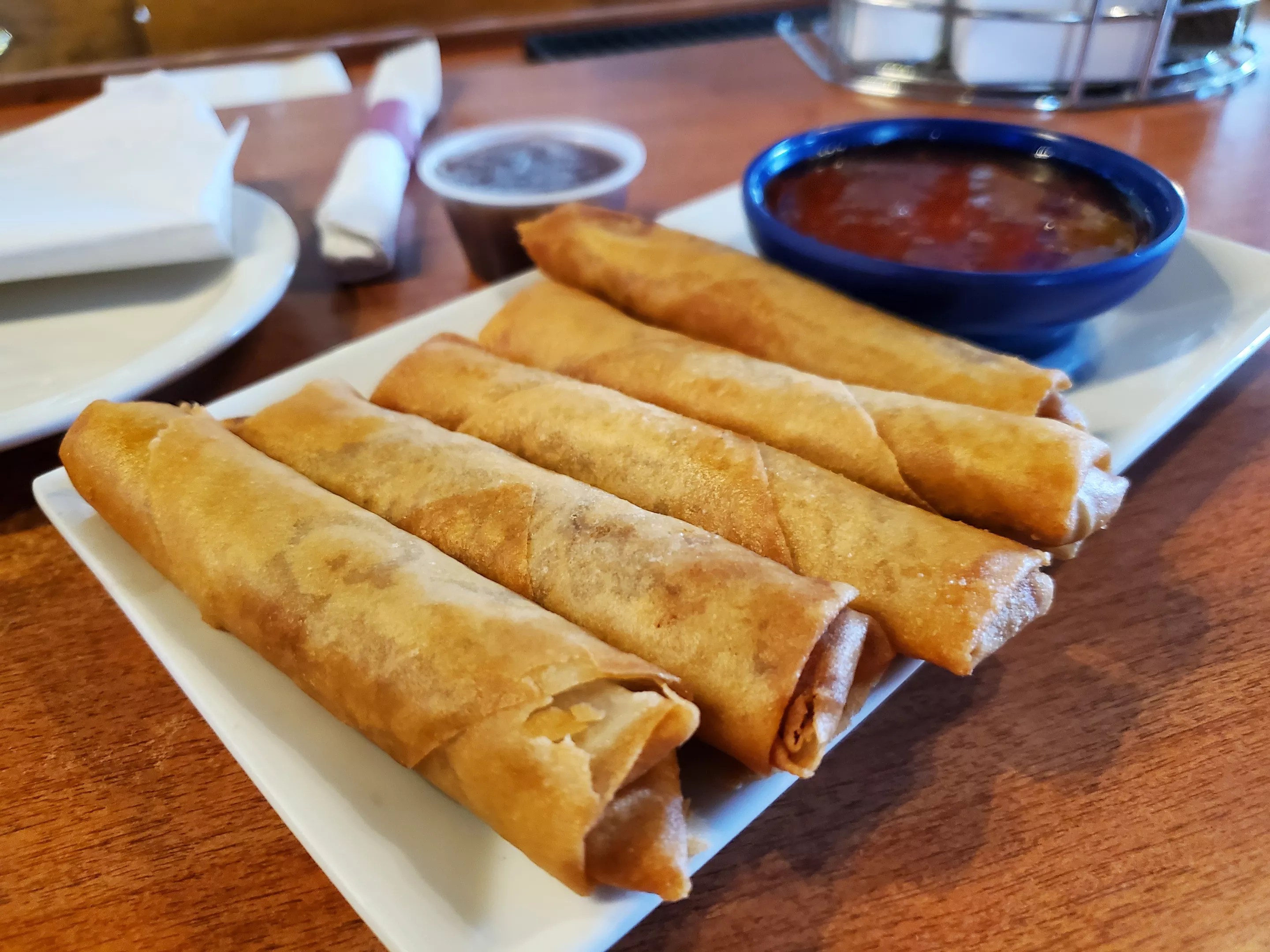 fried egg rolls on a place with a side of dipping sauce