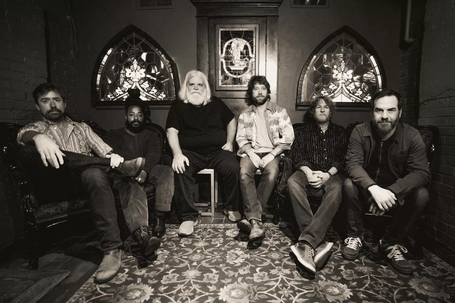 six bandmates sit in a room
