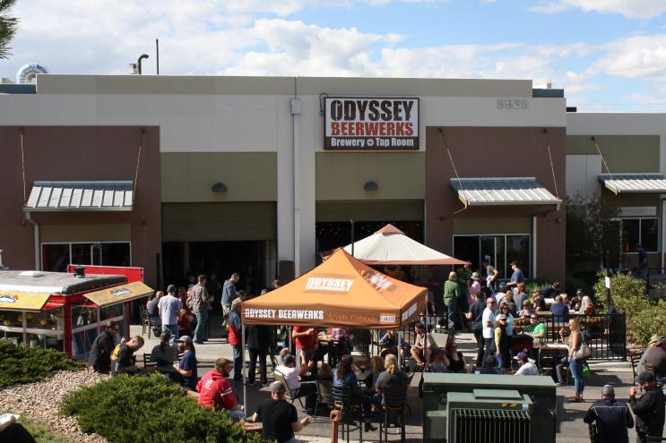 a patio fiilled with people, tables and tents