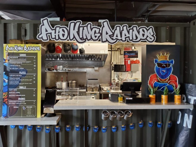 the front of a food stall with its name written in graffiti font
