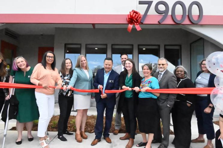 Jeff Martinez, the president of Brothers Redevelopment, Kate Kerkmans, the CEO of the Brain Injury Alliance of Colorado, and other partners join the ribbon cutting for Valor on the Fax in Denver, Colorado.