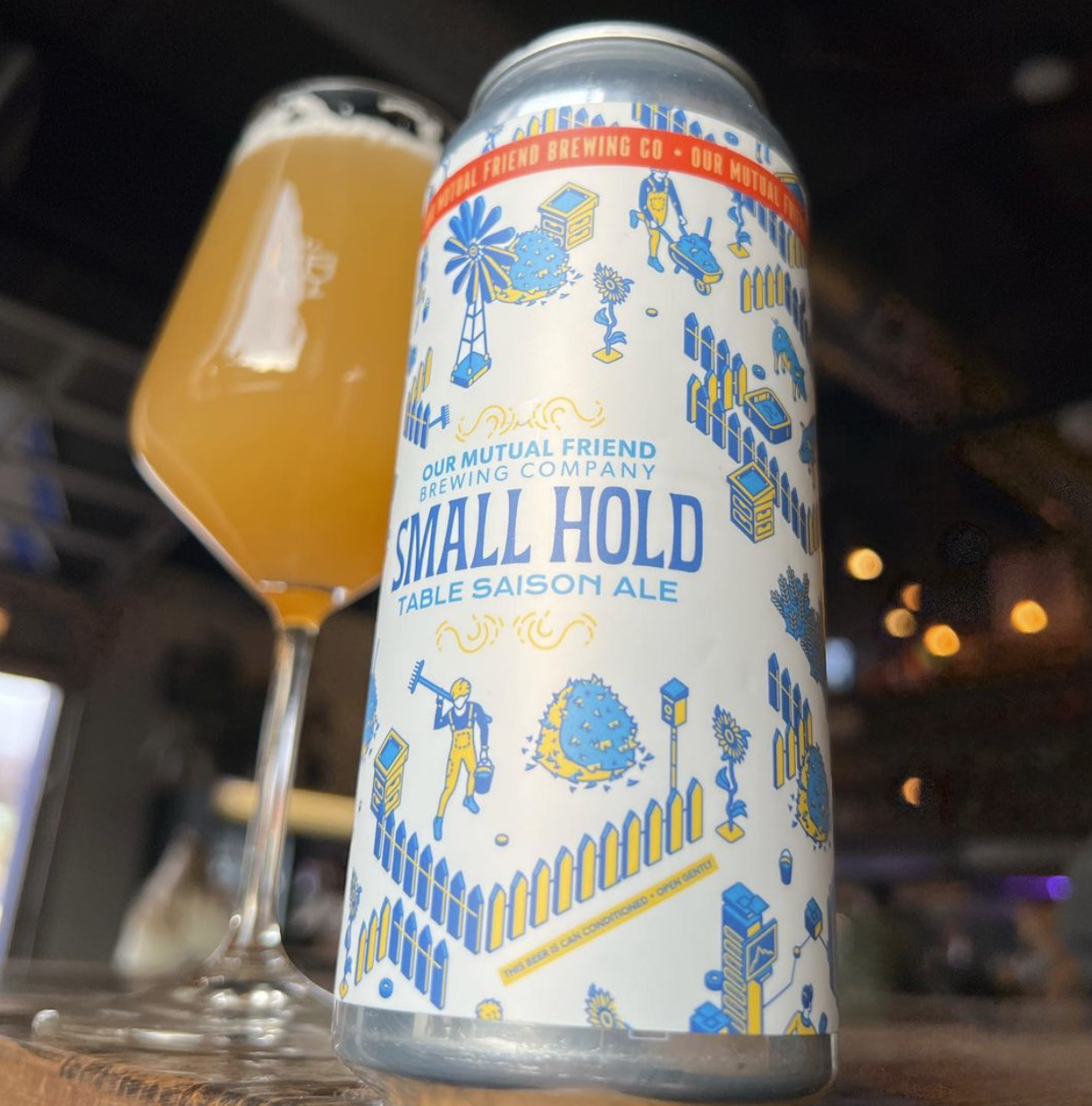 Can of beer in front of a stemmed glass filled with beer