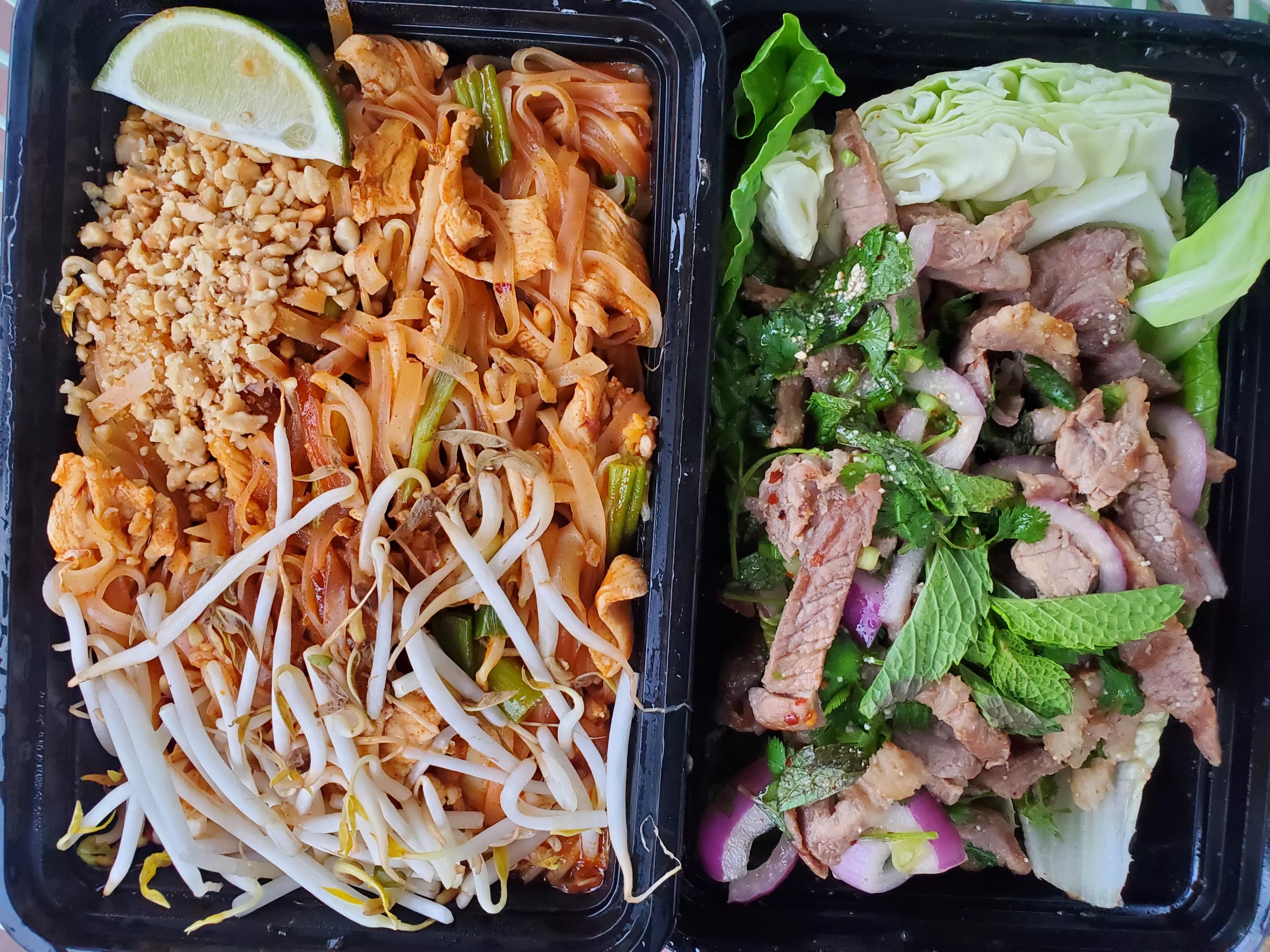 two to-go boxes open and filled with food