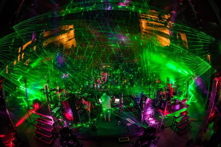 dj performing on stage with a light show