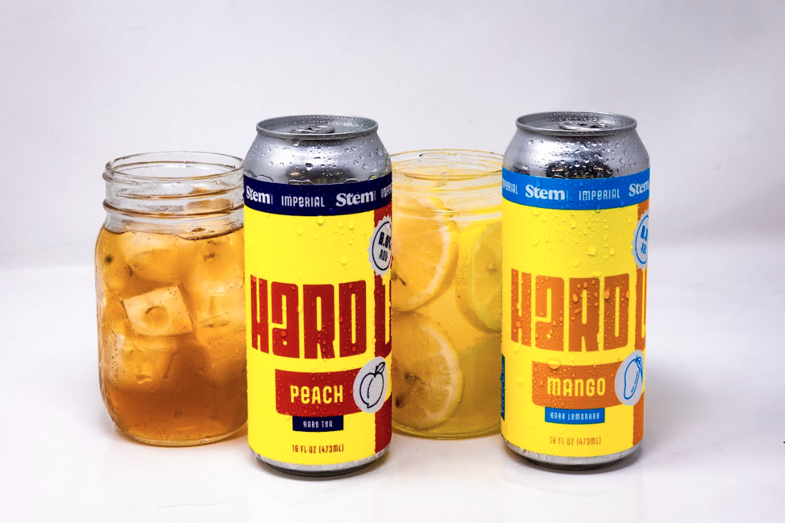 two mason jar glasses next to two cans