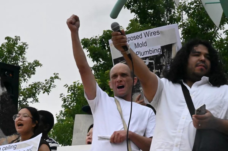 Michael Lunsford holds up his fit alongside other protesters at a rally at Fletcher Plaza in Aurora.