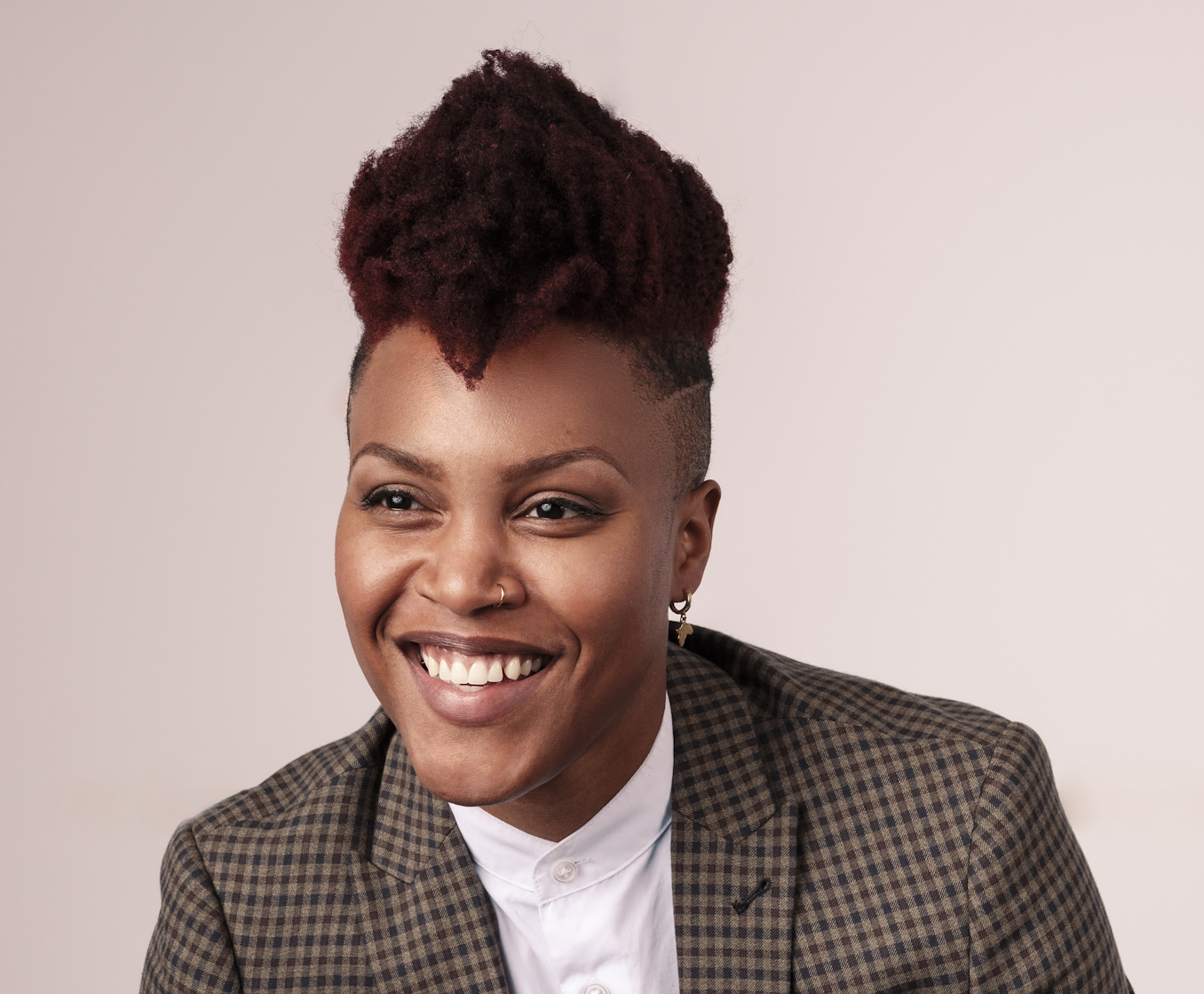 black woman smiling in a suit jacket over a white shirt