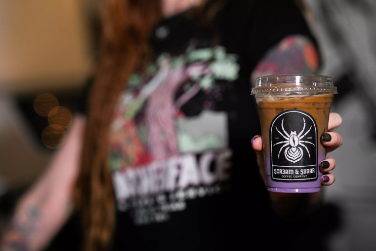 person holding a purple drink in a cup