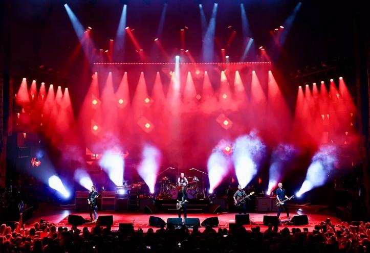 band on stage with red lights in the background