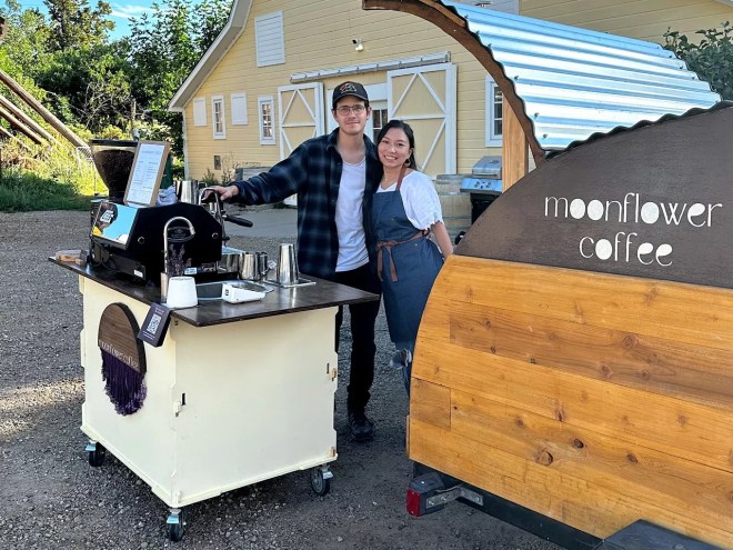 two people standing next to a coffee cart