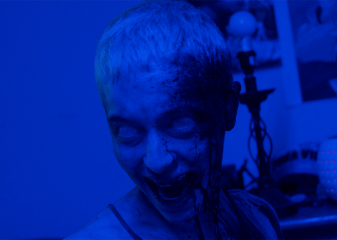 blue lighting covers woman with short hair and fangs
