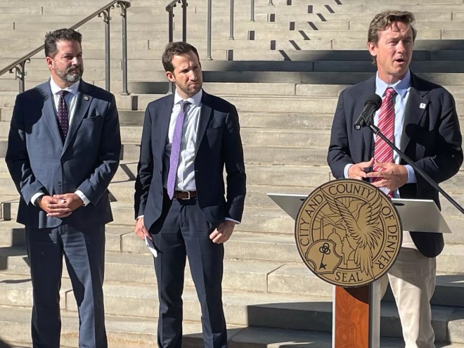 Mayor Mike Johnston speaks alongside a pair of high-ranking federal officials.