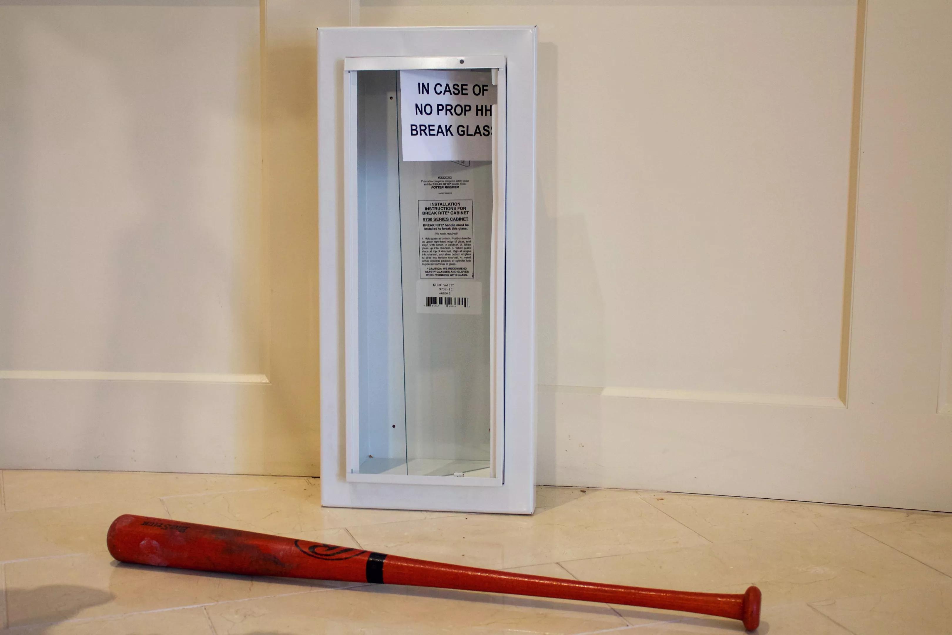 A bat and emergency case used by Governor Jared Polis to illustrate his new plans for property tax relief in Colorado.