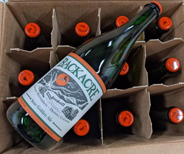 Bottle of beer resting on a case of beer.