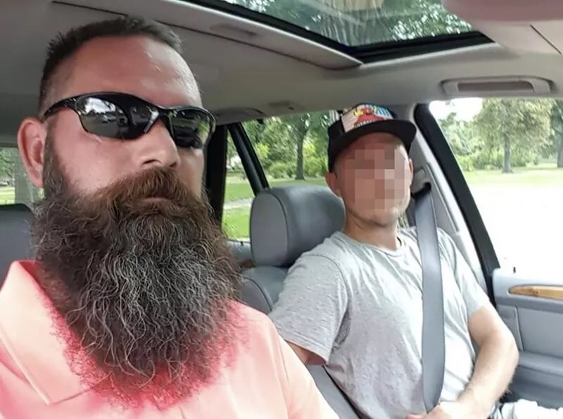 two men in car, one with beard
