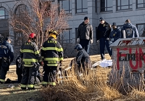 Firefighters use a power tool.