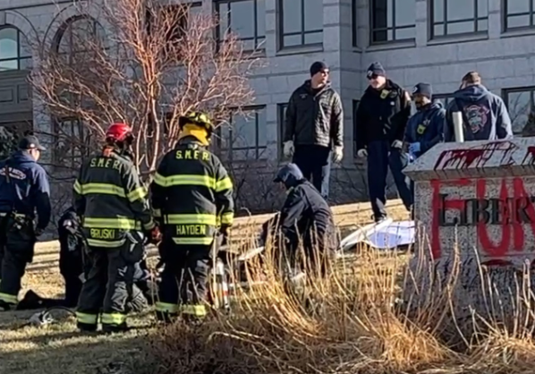 Firefighters use a power tool.