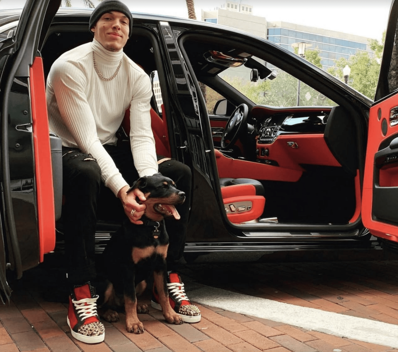 Denver Nuggets player Aaron Gordon posing with his Rottweiler for a picture.