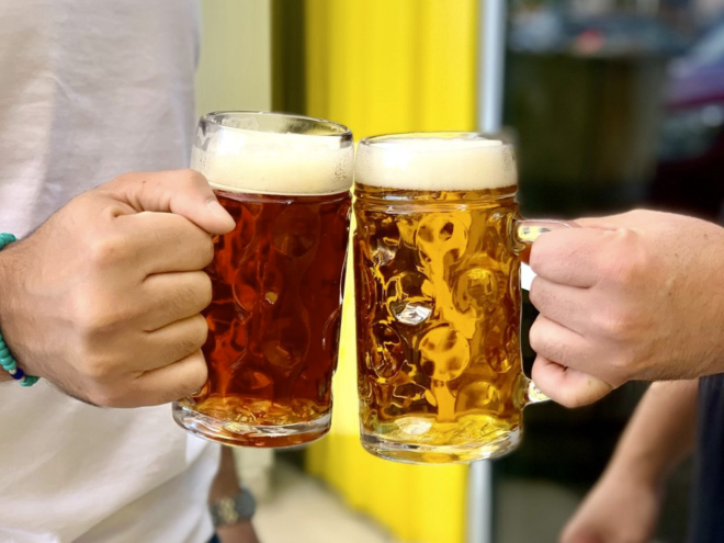 hands holding two pints of beer