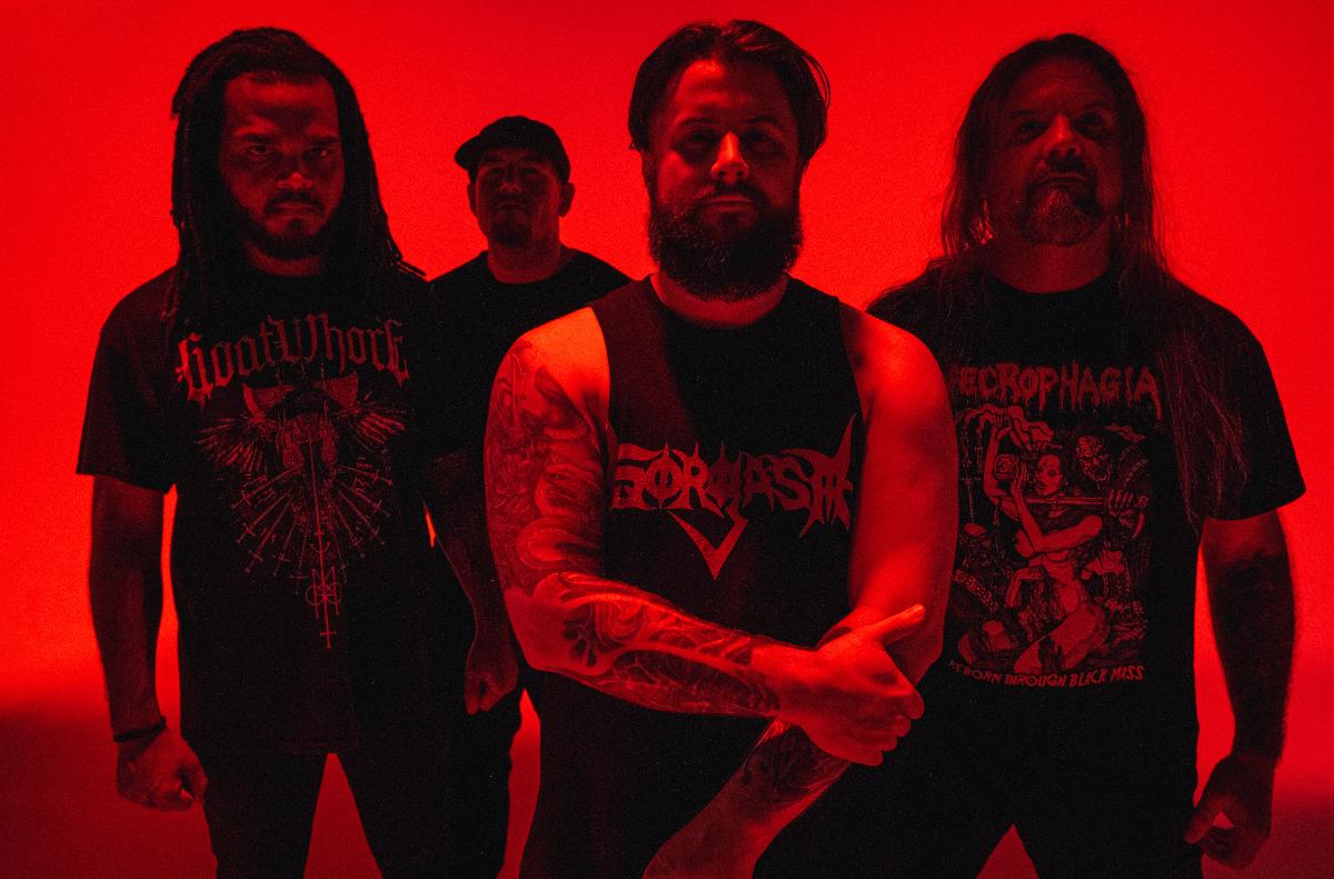 bandmates pose for photo in red lighting