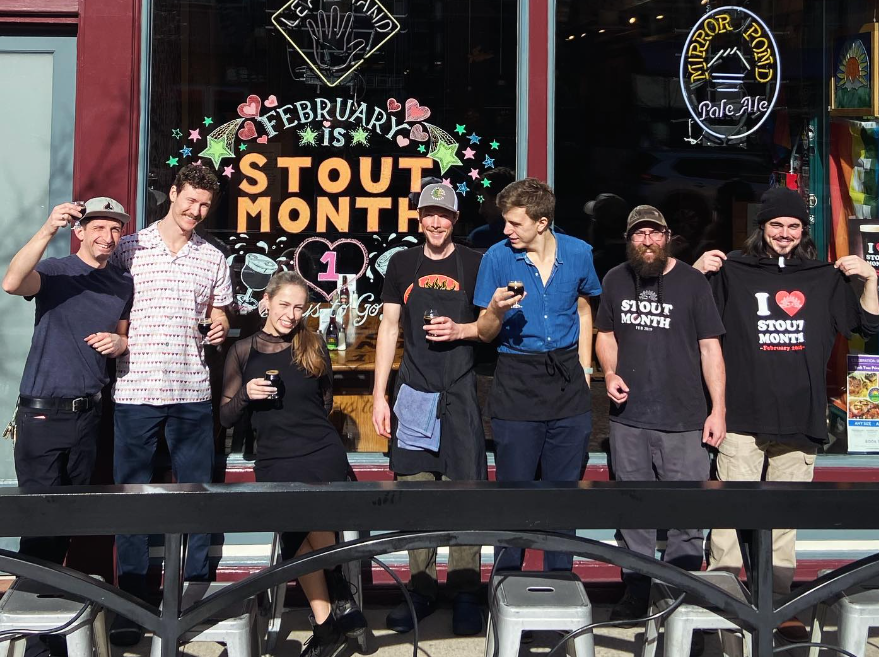 a group of people posing in front of a window