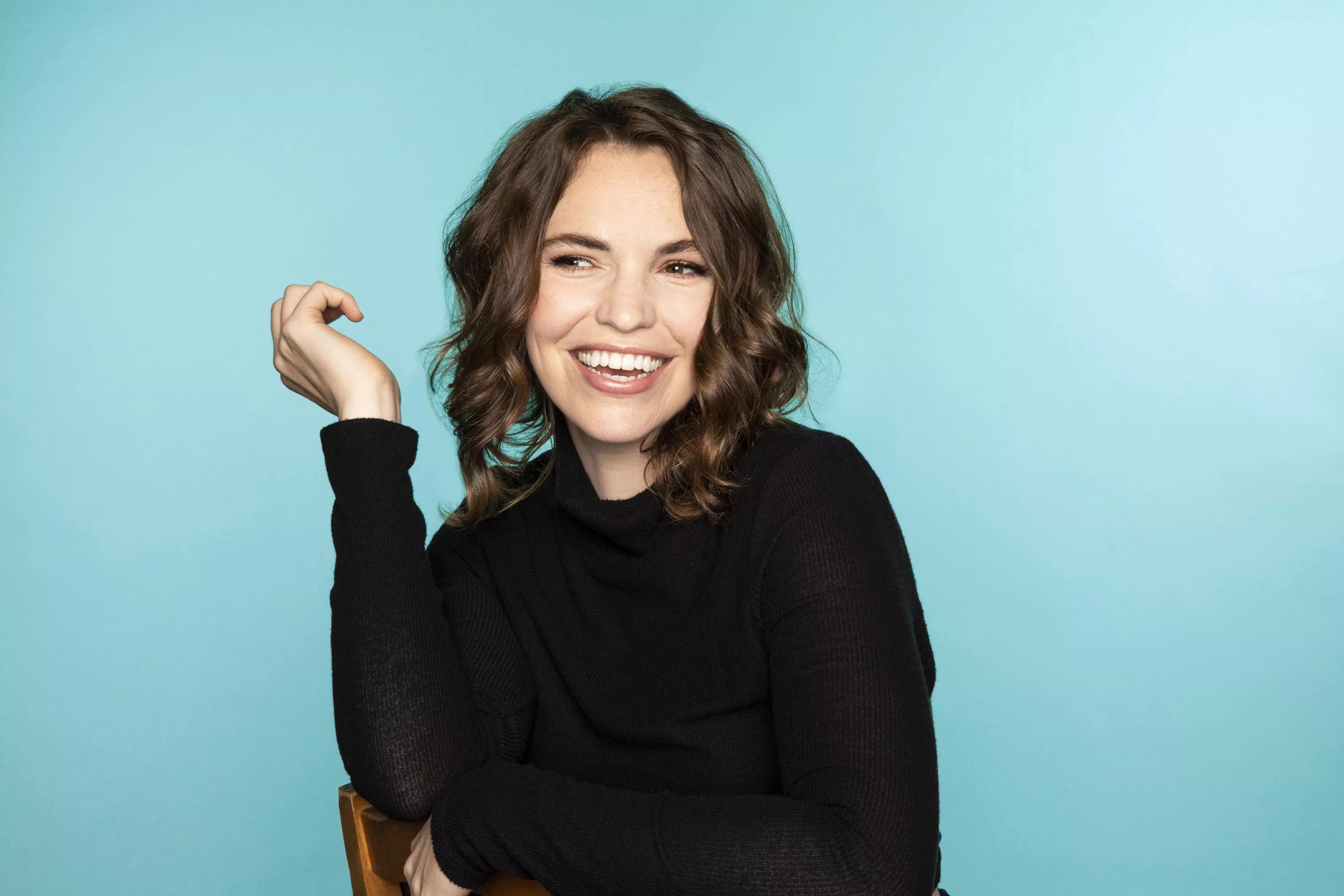 brunette woman smiling in black longsleeve shirt
