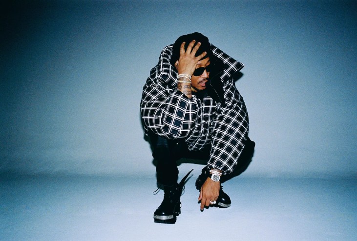 man crouched holding his head