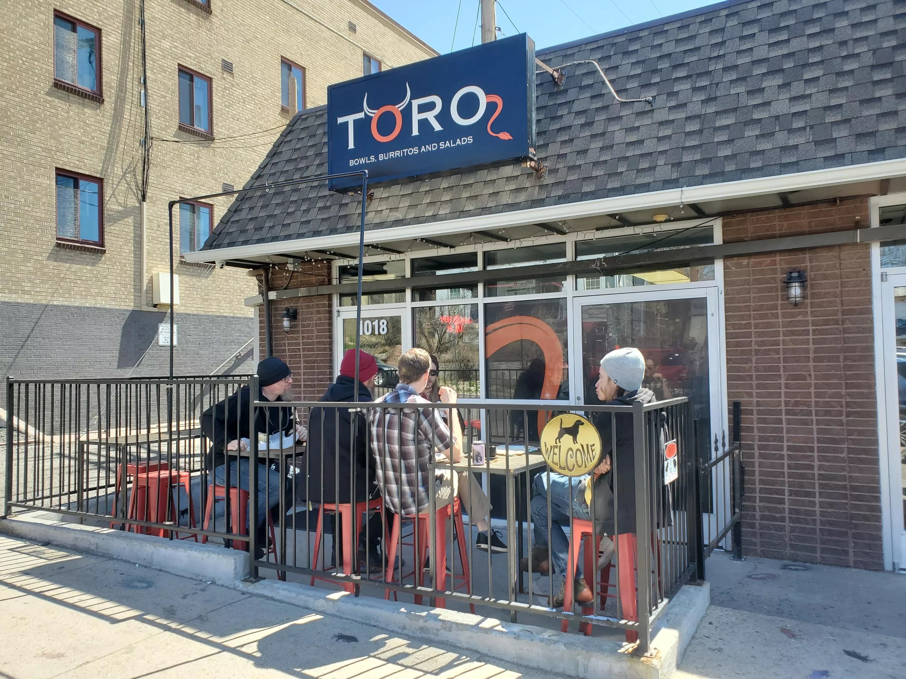 people sitting on a patio in front of a restaurant