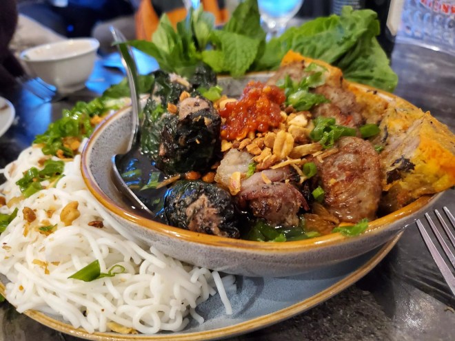 noodles next to a bowl of various meats