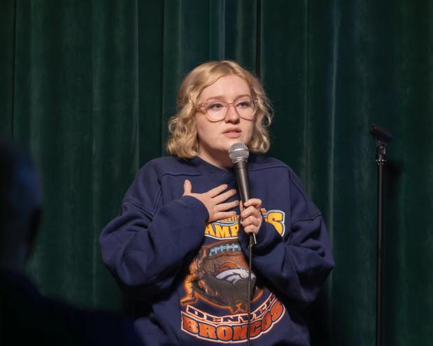 blonde woman with glasses at a microphone