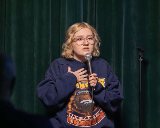 blonde woman with glasses at a microphone
