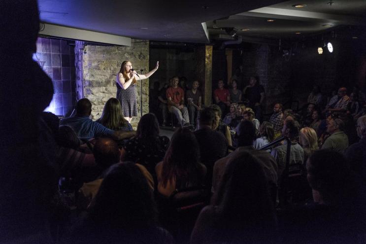 woman doing standup at a comedy club