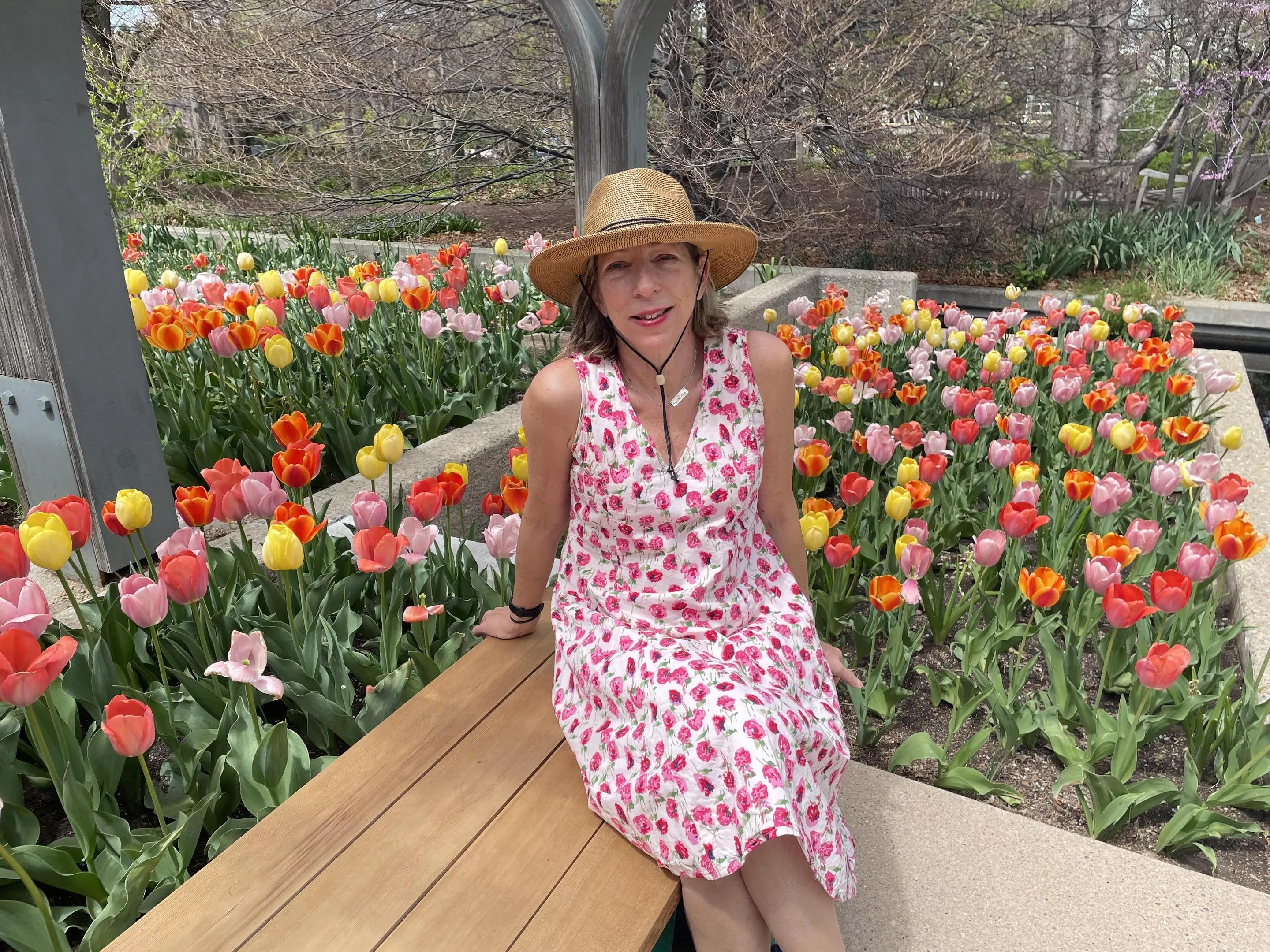 woman in flowered dress sitting in garden