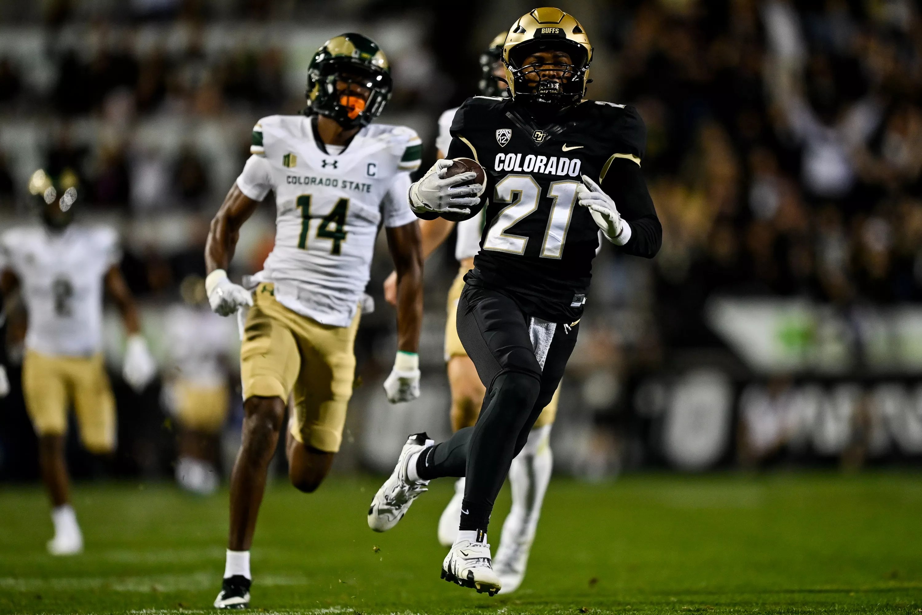 CU football player Shilo Sanders runs back an interception against CSU