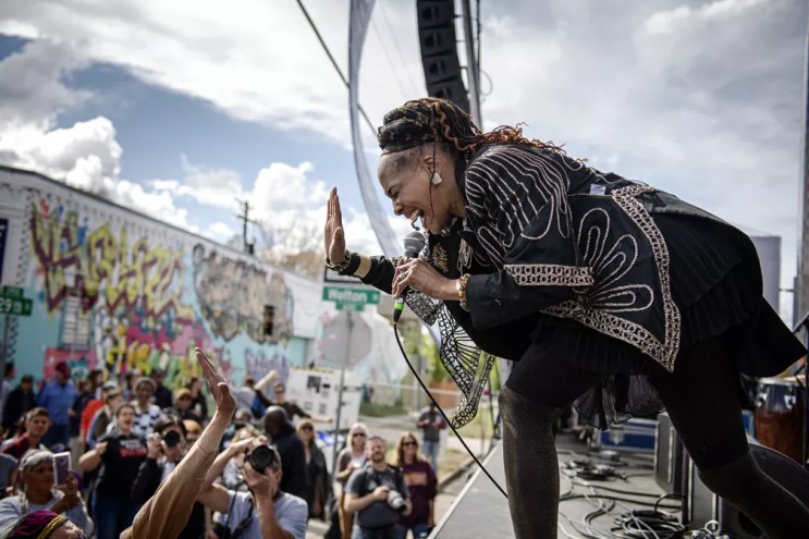 woman singing on a stage to a crowd